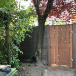 Beton-beton schutting met hardhouten poort